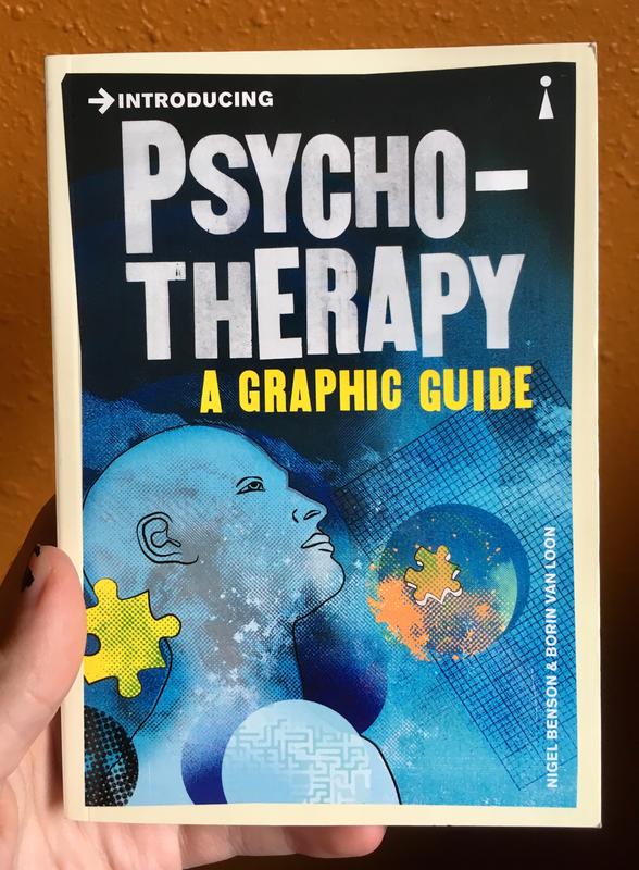 Book cover titled Introducing Psychotherapy. It is blue, with an androgynous bald head and two puzzle pieces which are yellow and orange.