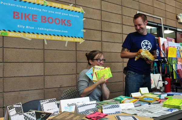 A photo of Microcosm's editor and publisher showing off the sweet bicycle books they made