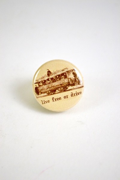 Button with an illustration of historical cyclists and the words Live Free or Drive