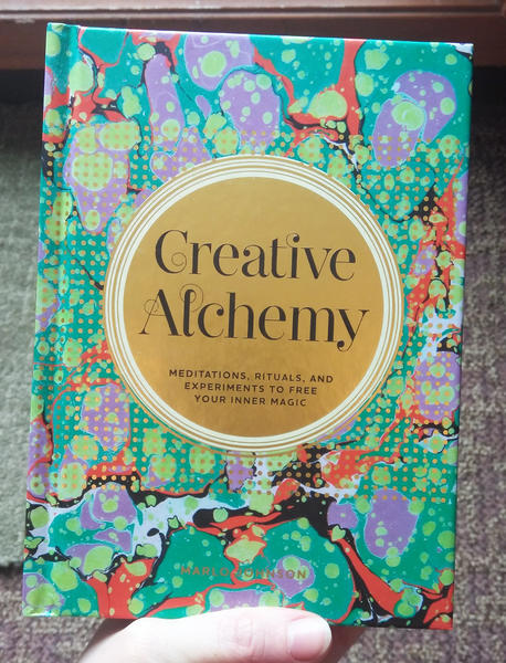 Cover of Creative Alchemy: Meditations, Rituals, and Experiments to Free Your Inner Magic which features the title in a gold circle on a multicolored abstract background.