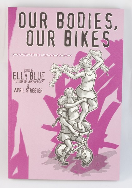 A pink book with an illustration of three women riding the same bike, holding each other together