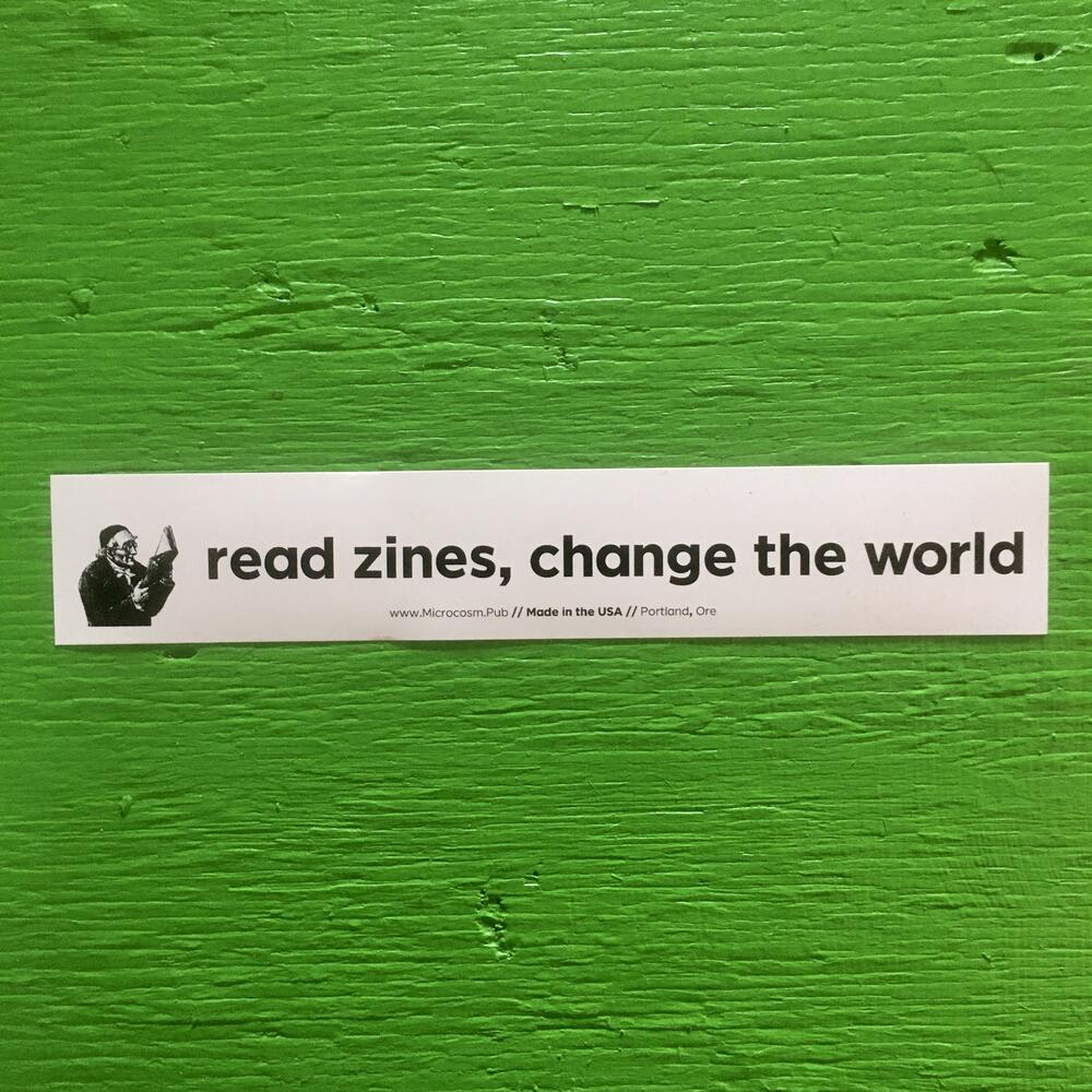 a sticker saying "read zines, change the world"
