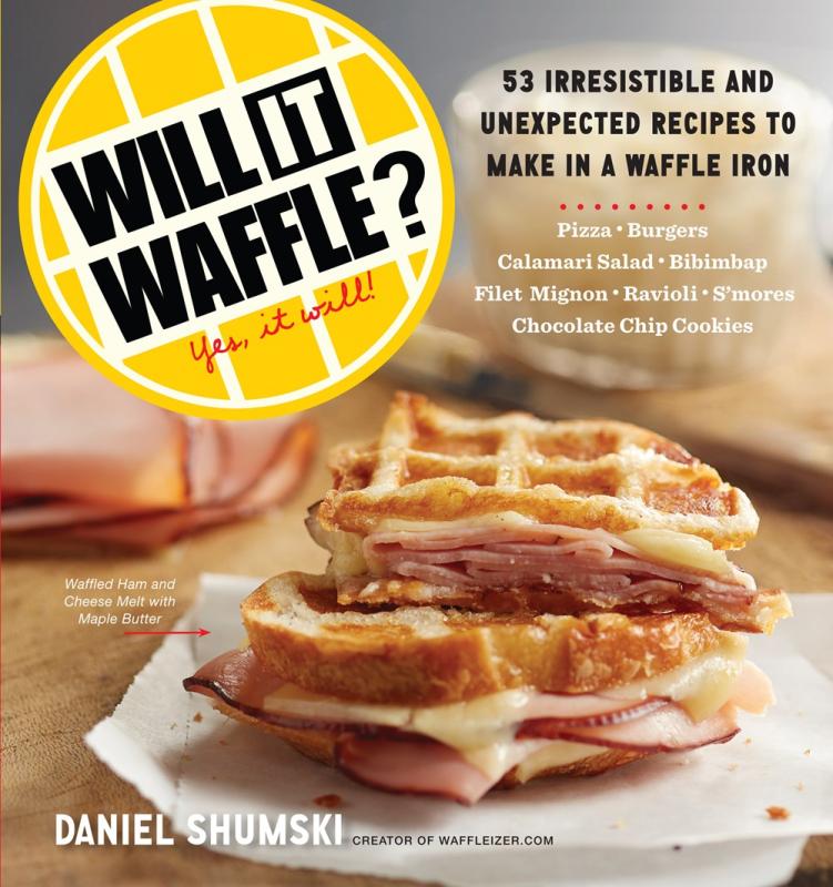 Blurred background of a table featuring a ham, cheese, and maple butter waffle sandwich