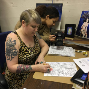 a woman photographs another woman coloring