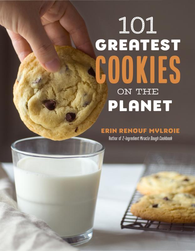 hand dipping a cookie into a glass of milk