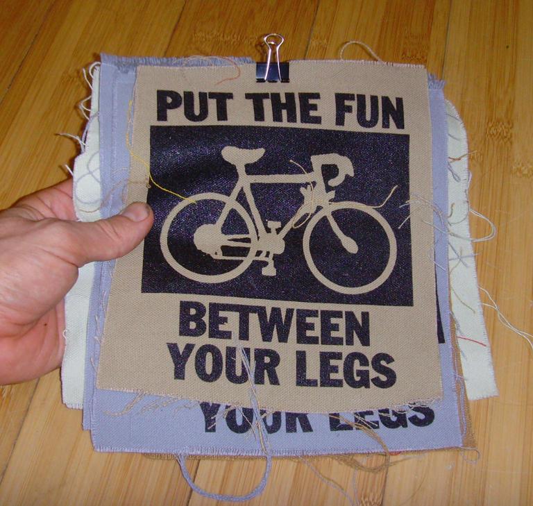 A canvas patch with a bicycle printed on it and the text Put the Fun Between Your Legs.