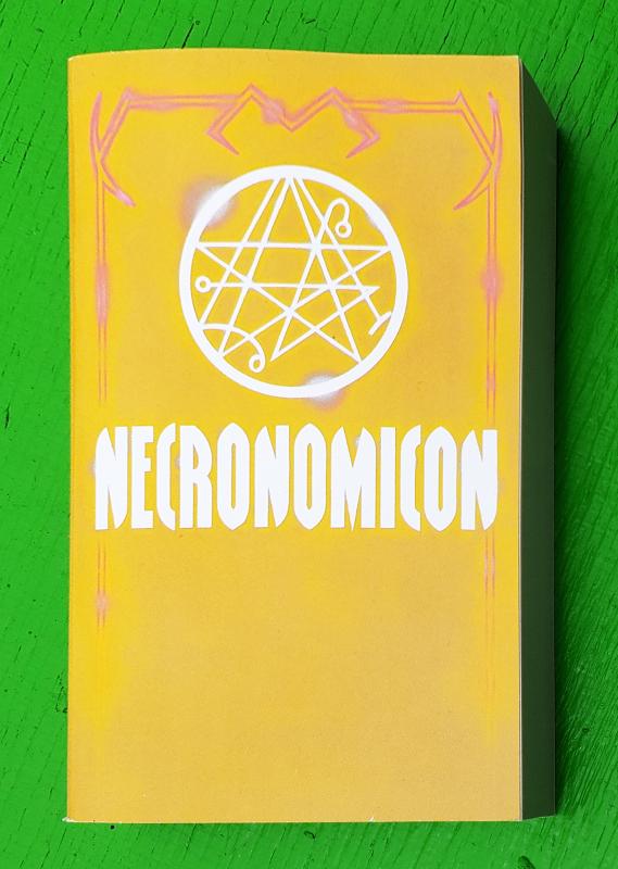 a yellow paperback with some satanic symbolism