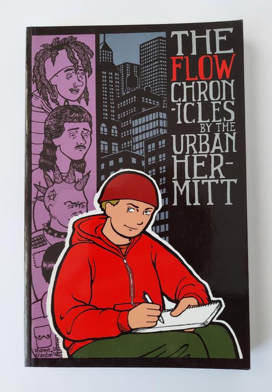 A black book with a drawing of a man in a red hoodie writing in a notebook