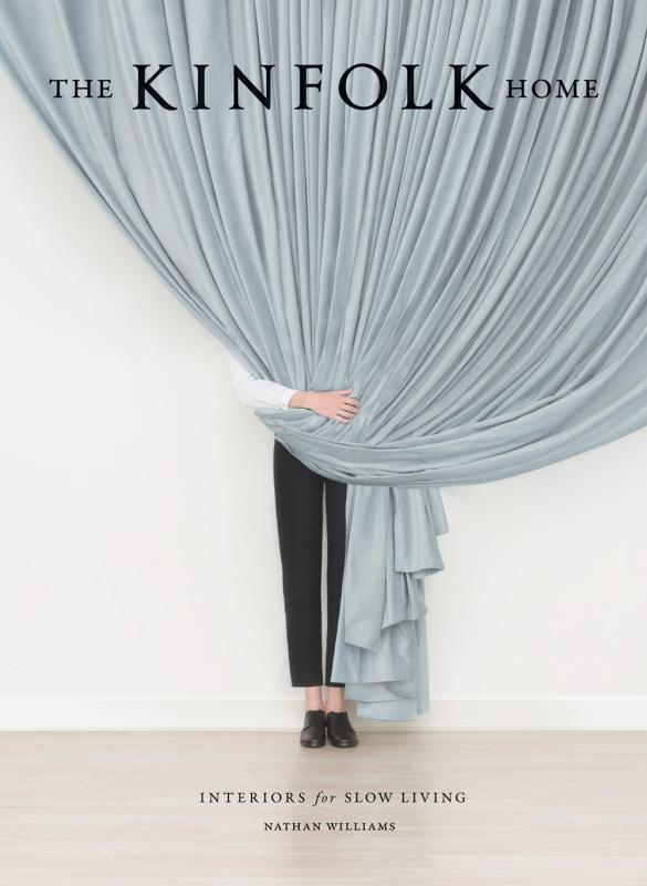 Person in pants stands behind a curtain over a off-white wall and floor