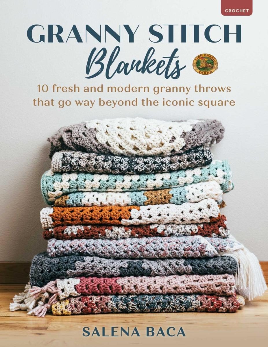 Crocheted blankets in a stack, on a table against a wall