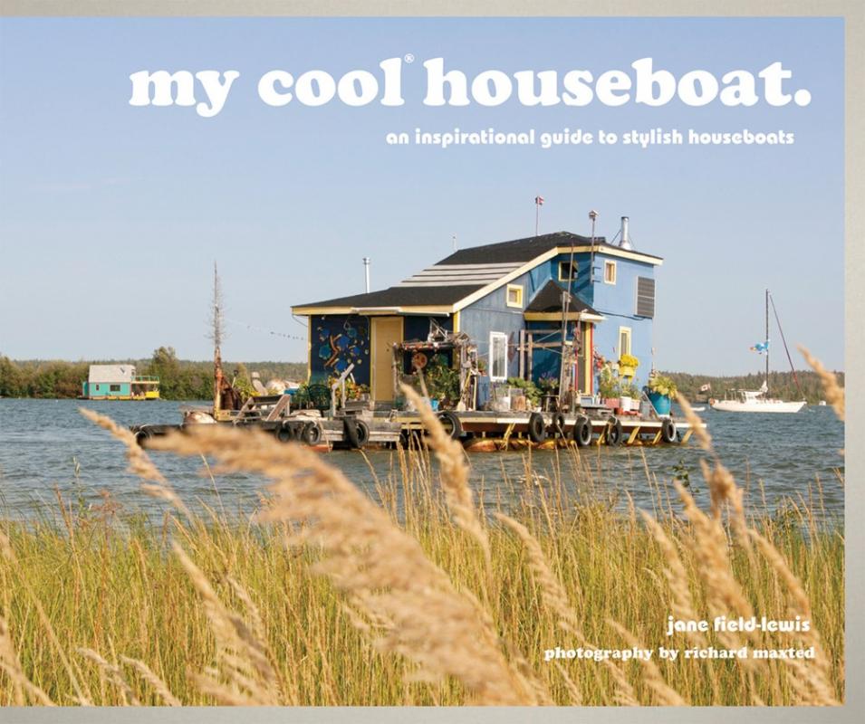 Image of houseboat floating on water seen through tall grass