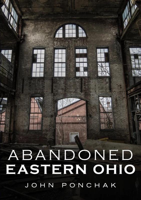 Inside of an abandoned brick building with high ceilings, and windows