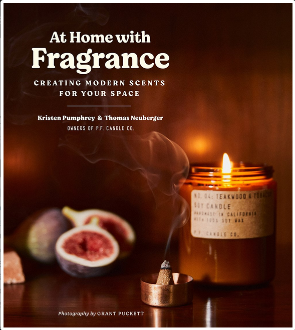 Photo of a burning candle and small incense nub against a dimly lit wooden background with pomegranates. Text is white.