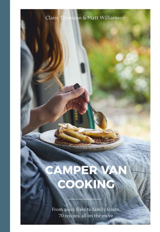 Close up shot of a plate with food on a person's lap, sitting on the edge of a van with an ajar door with a a blurred out of focus background of greenery