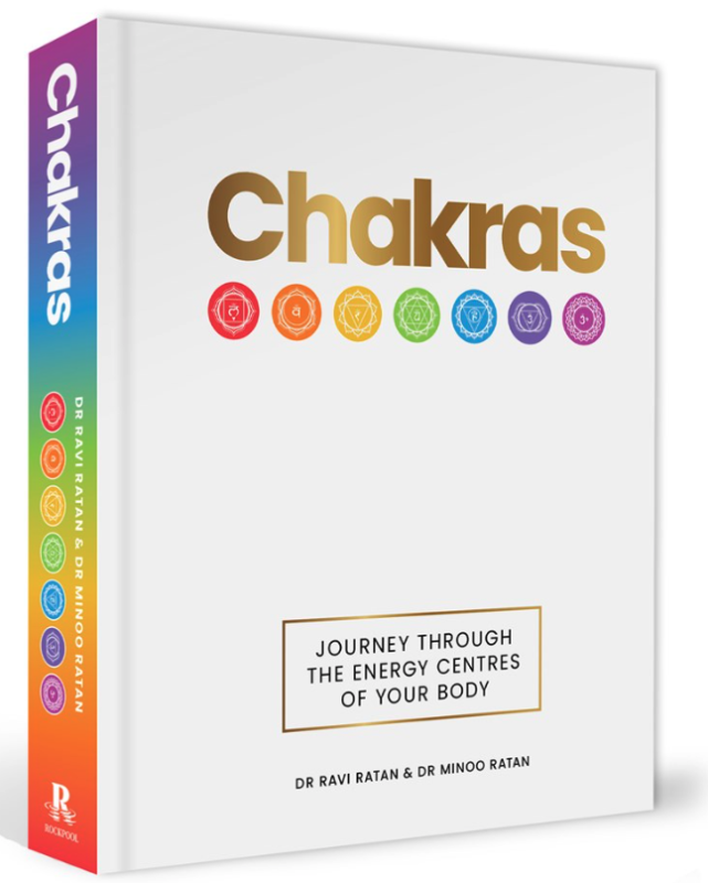 White cover with rainbow chakra symbols underlining the title (hardcover).