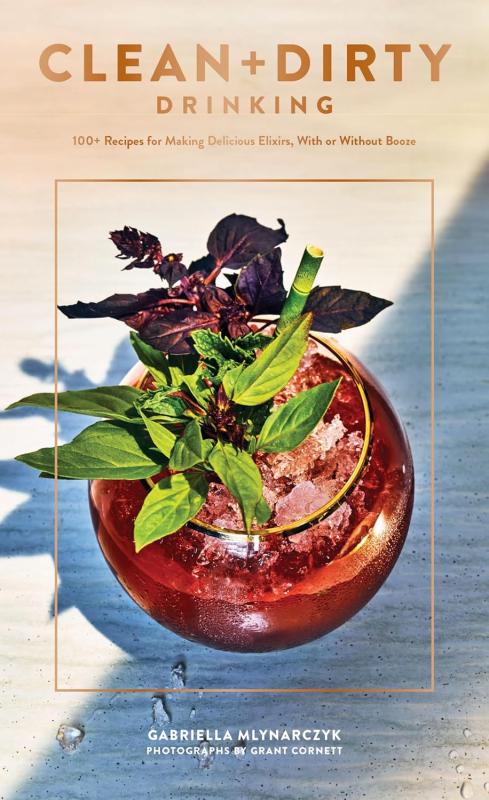 Herbal red drink in a spherical glass with ice and a bamboo straw