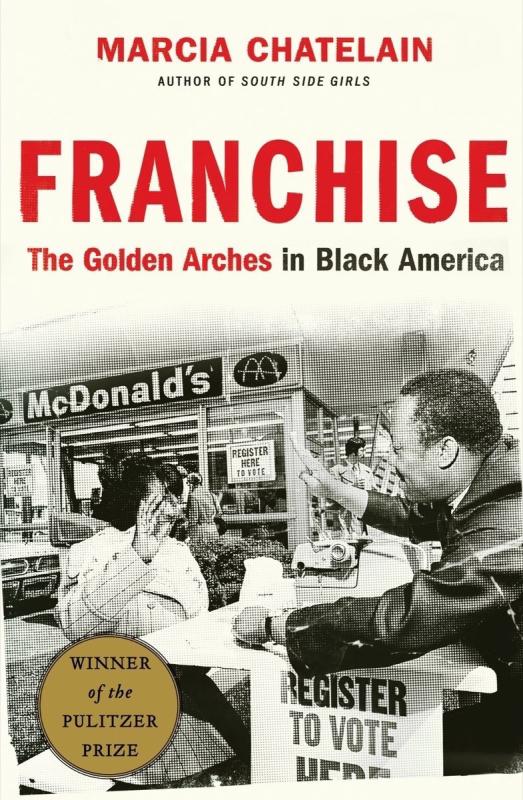 historical black and white photo of two people sitting at a table at a McDonalds