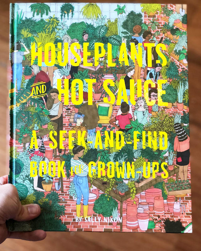 Hand holding copy of Houseplants and Hot Sauce