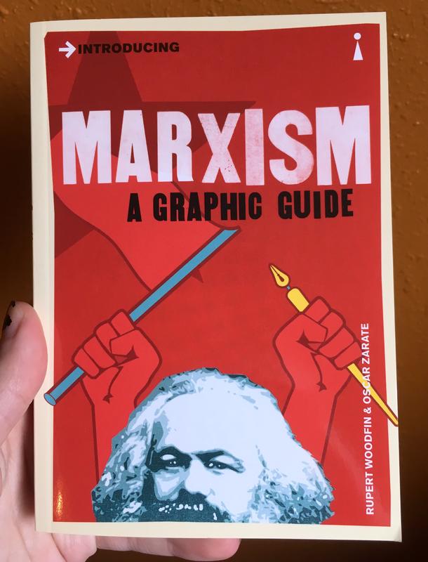 red book cover depicting karl marx's head and two hands holding a stick and a pen