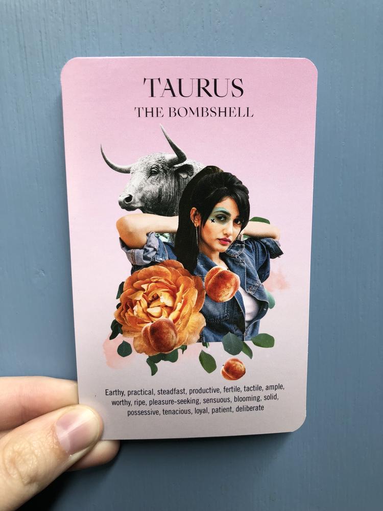 Taurus card, with a woman posing, an ox behind her, an orange flower, and peaches. 