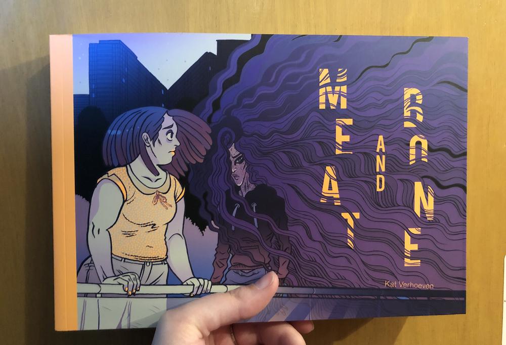 Two people on the left, one looking out over a railing, the other has long flowing purple hair that takes over the right side of the cover, and is looking at the reader. 