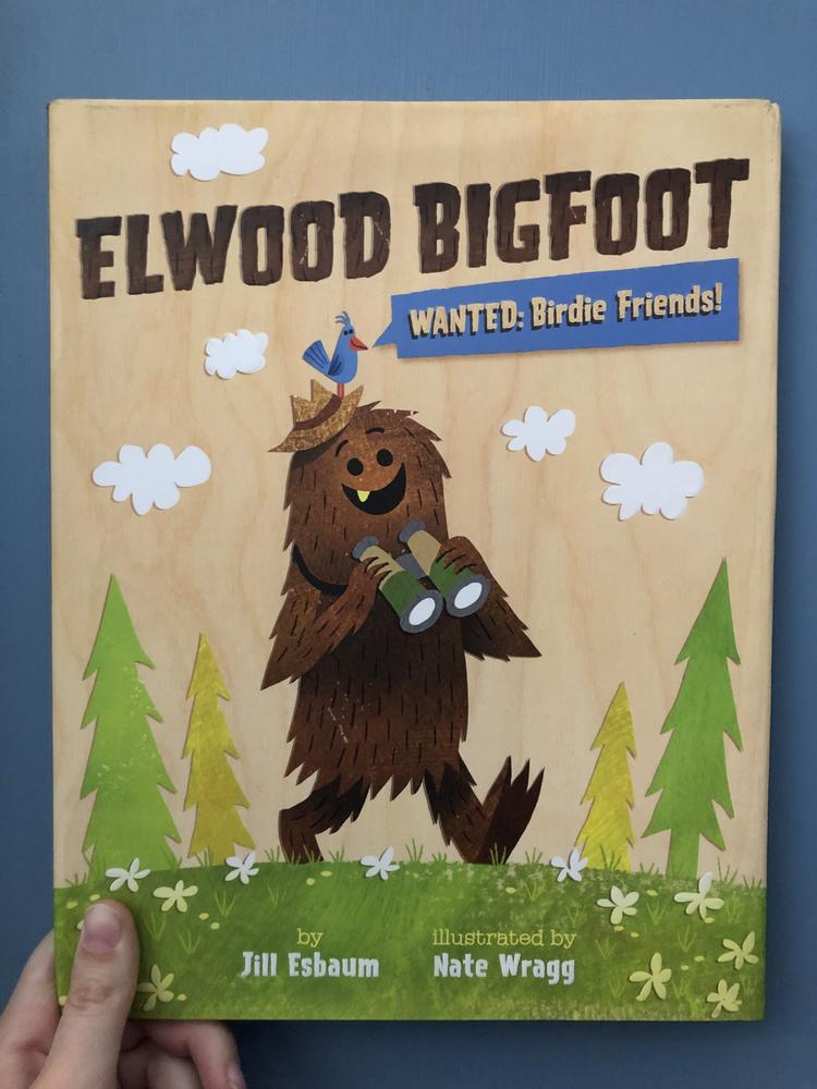 An illustration of Bigfoot walking in the woods, holding binoculars, with a small blue bird standing on his head. 