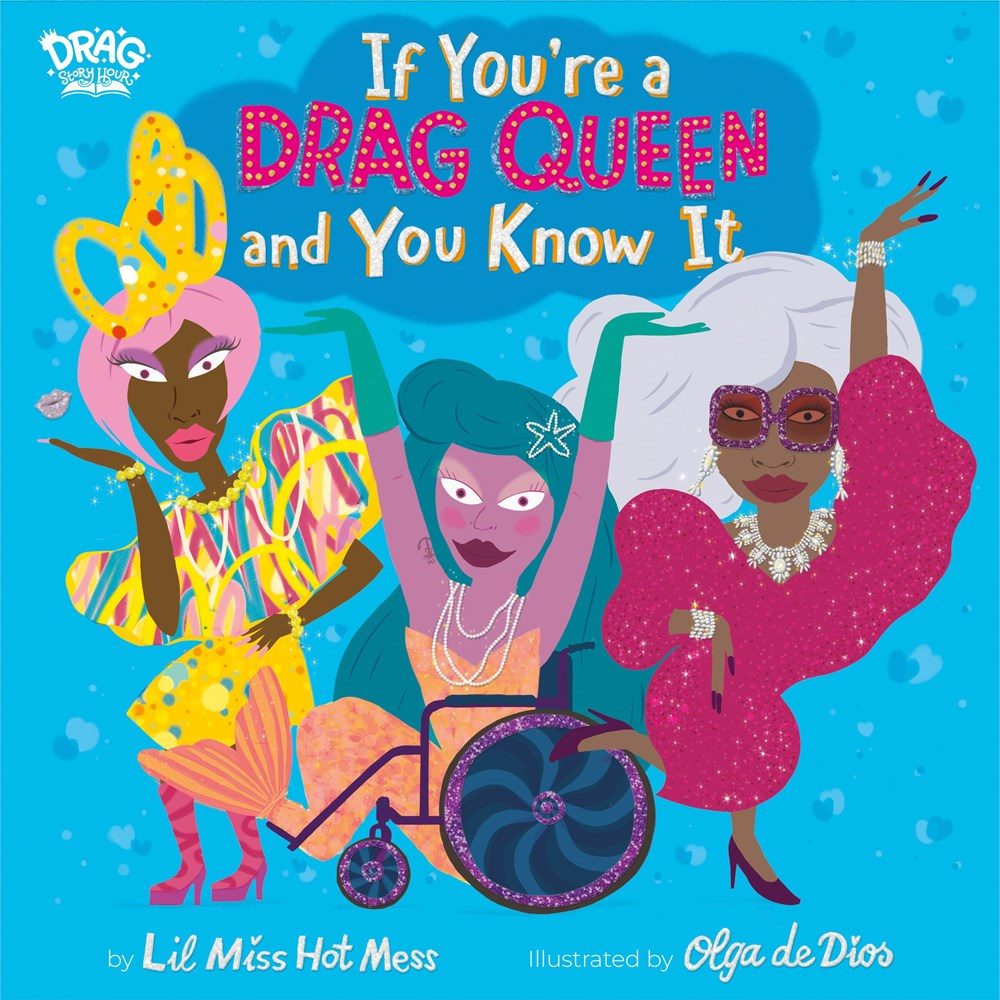 Three drag queens, the middle one in a wheelchair, all with hands in the air over a teal background