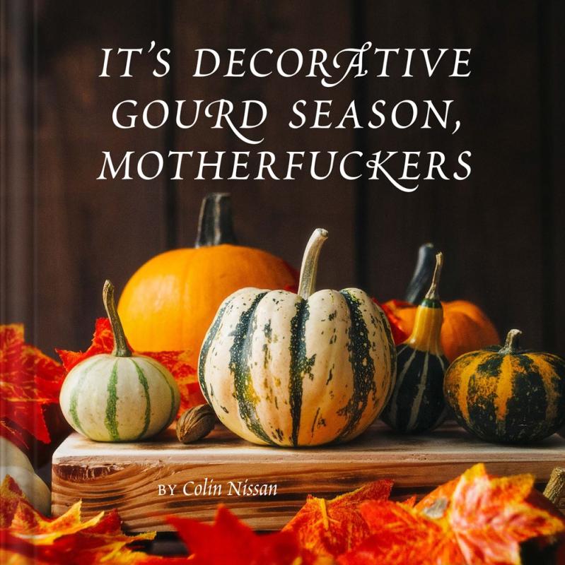 squash and gourds on a table surrounded by fall leaves