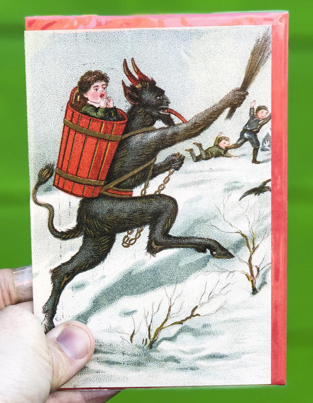 A devilish goat-like figure chases kids across the snow, a child in a barrel strapped to its back.