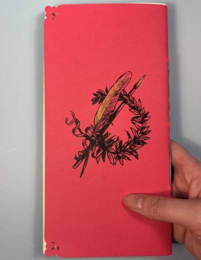 quill and a paintbrush in a wreath