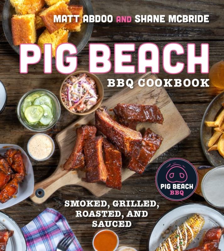 pig meat on a cutting board surrounded by other foods, in a top down view of a table