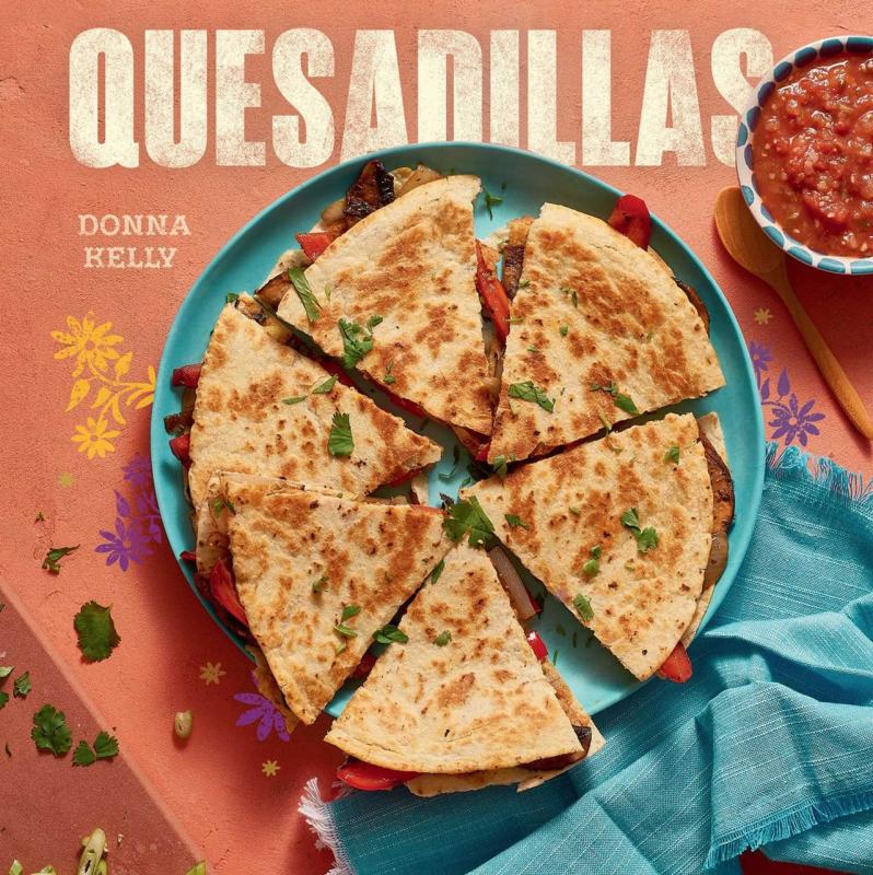 Quesadilla with meat on a plate next to a tablecloth and salsa bowl