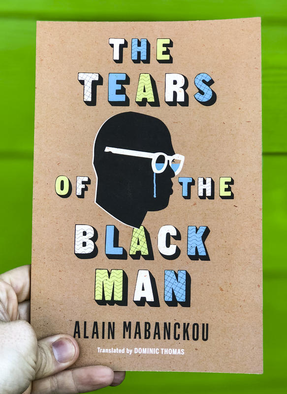 A silouhette of a black man crying, his glasses filled with his tears.