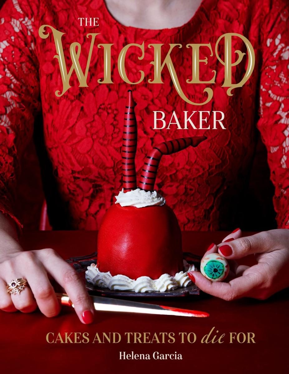 person in a red lacy shirt behind a funky cake with eyeballs
