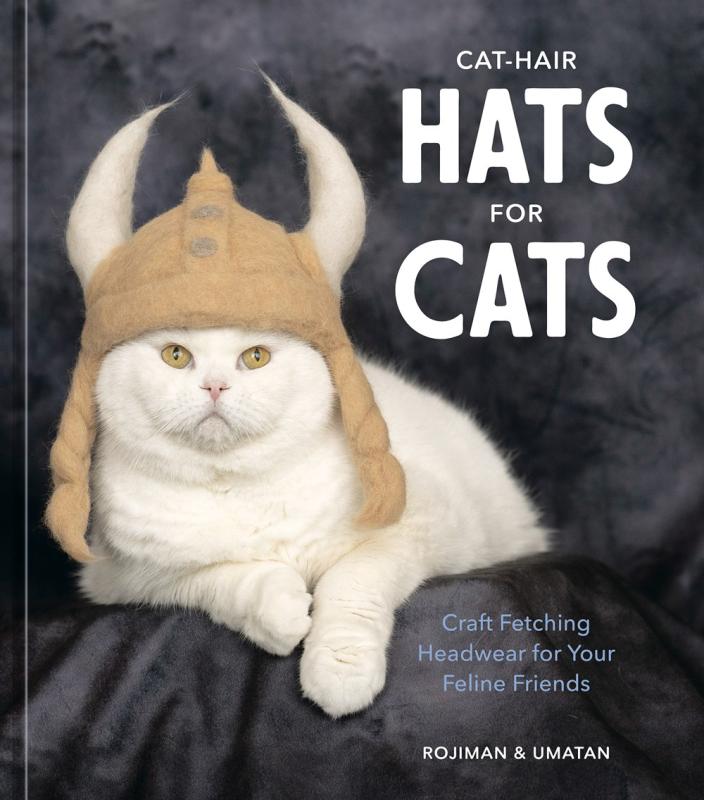 a photo of a white cat wearing a knit viking helmet