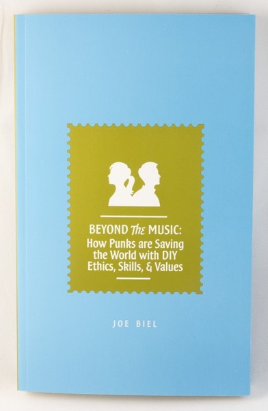 A light blue book with a green stamp and white silhouettes of a man and a woman, back-to-back