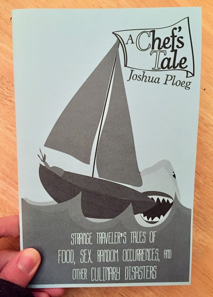 A zine with a shark taking a bite out of a small sailboat on the cover
