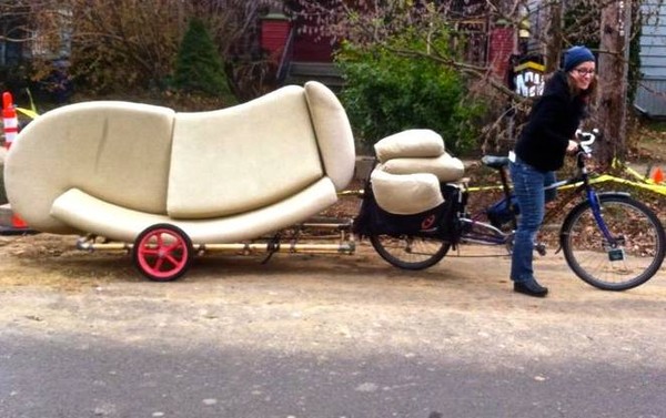Photo of a person pulling a couch on a bicycle