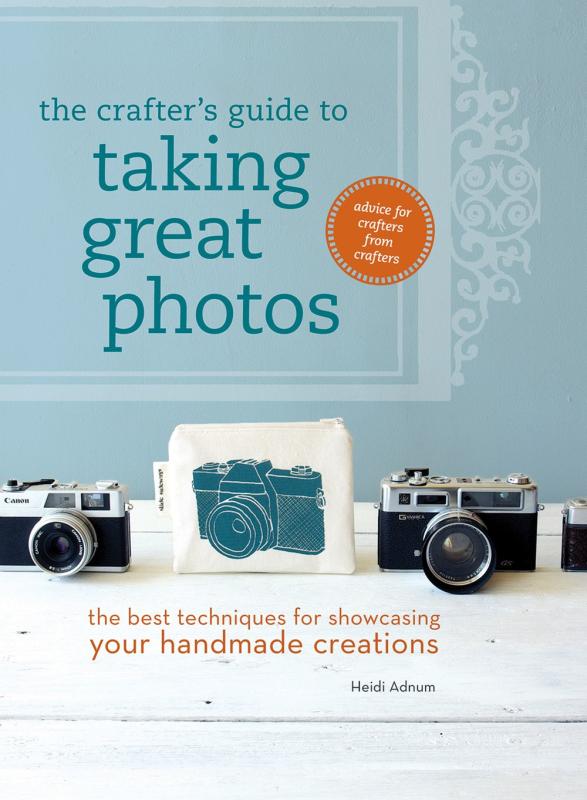 blue wall with white table with a line up of cameras with one being an illustration on a tote bag