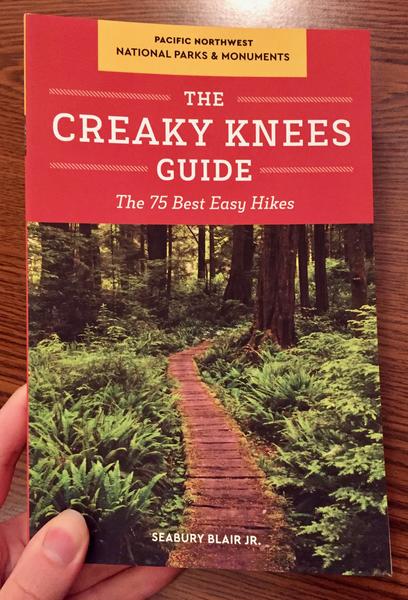 Creaky Knees Guide Pacific Northwest National Parks and Monuments: The 75 Best Easy Hikes [A wooden walkway meanders through a fern forest.]