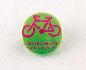 Creates Health Saves Money pink and green button with pink bike