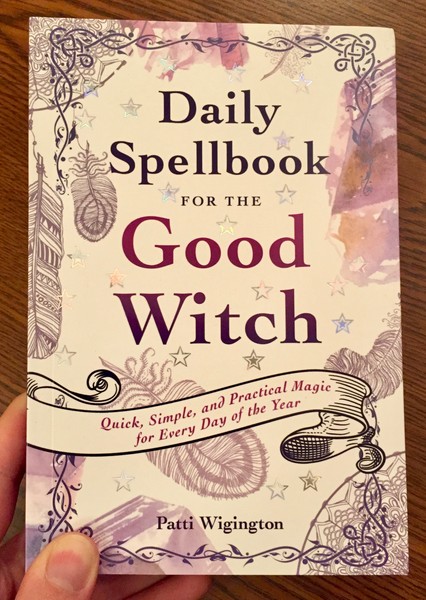 Cover of Daily Spellbook for the Good Witch by Patti Wigington which features ink drawings of feathers with splotches of purple and orange watercolor