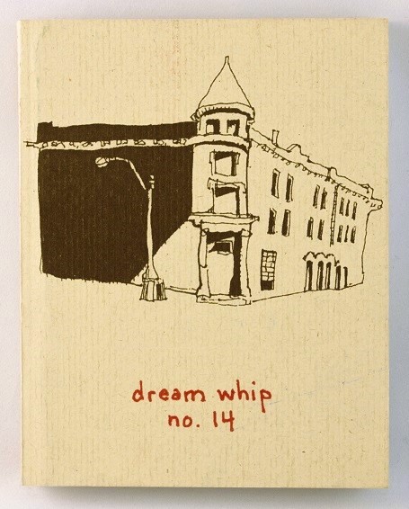A small, white book with a sketch of an older building and a streetlamp
