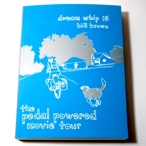 A blue book with an illustration of the back of a cyclist and dog riding/running down the road