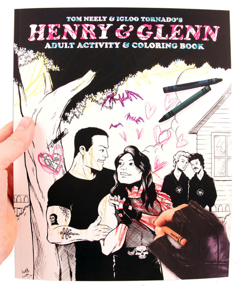 A hand with a black fingerless glove colors in Henry & Glenn next to a tree on the cover