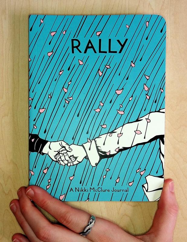 A blue cover with cherry blossom petals raining down - two hands from two different people are grasped on the cover, the right one pulling the left one forward.