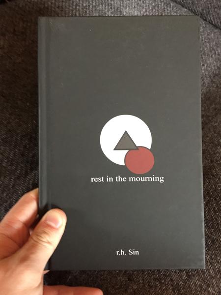 Rest in the Mourning by r.h. Sin (a grey triangle is centered in a white circle and pierces a red circle with its bottom right corner: on a black background)