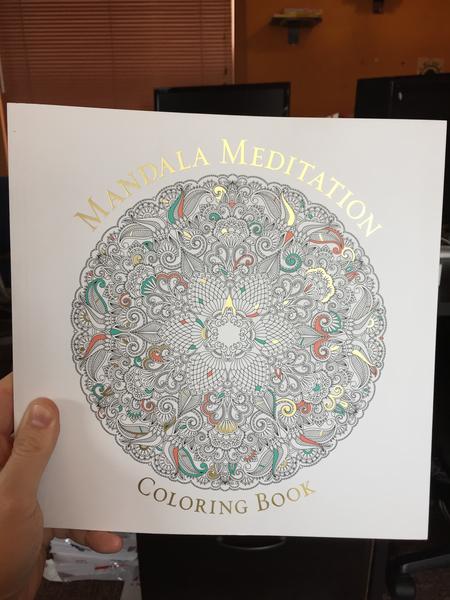 Mandala Meditation Coloring Book (A mandala on the cover with oranges, golds, and blues filled in, on a white background)
