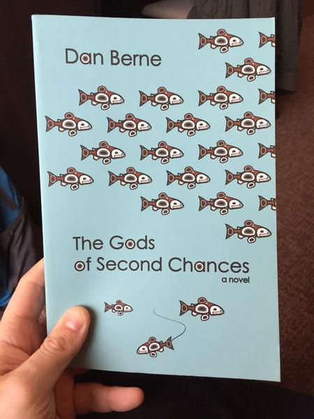 The Gods of Second Chances: a novel by Dan Berne (The background of the cover is light blue, ancient, tribal looking fish swim in a school across it.)
