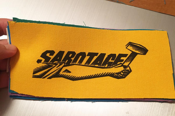 The word “sabotage” written above an arm holding a hammer.